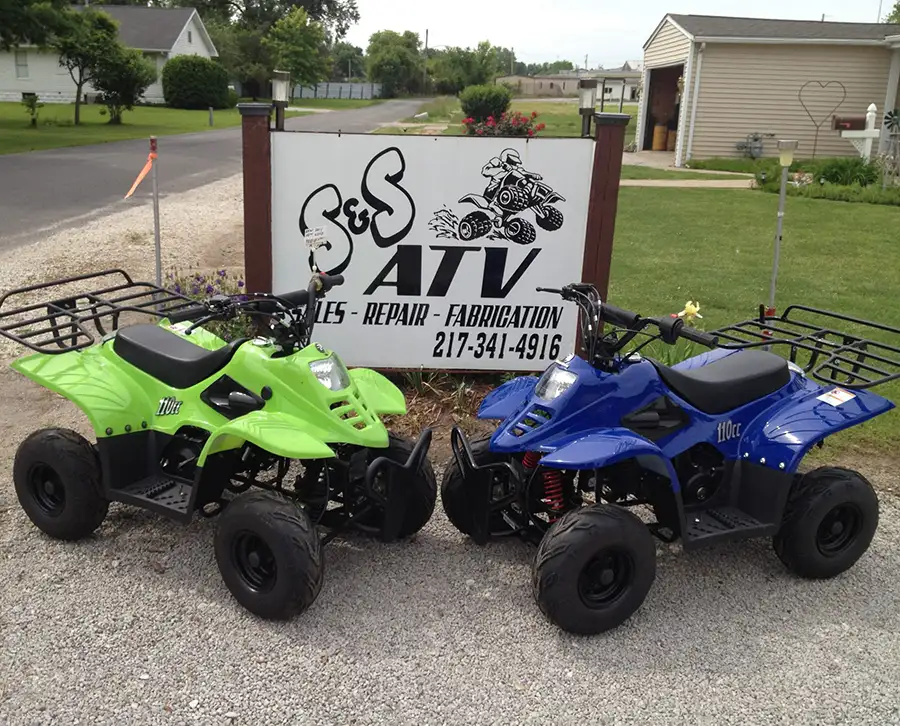 S&S ATV Sales & Services - ATVs in front of shop location sign - Carlinville, IL